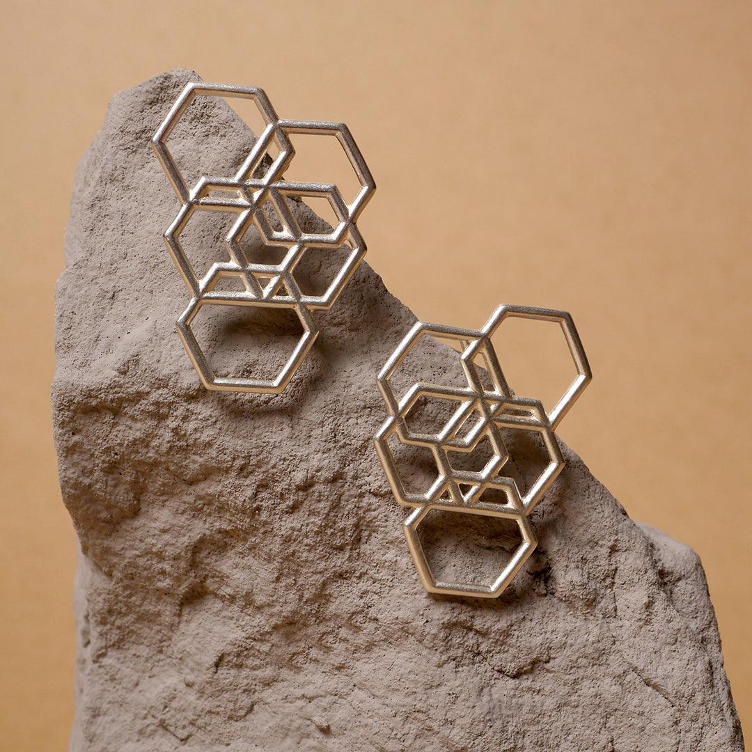 Aretes hexágonos entrelazados en plata 925, foto ambientada. Joyería hecha a mano que refleja estructura y elegancia. Diseños exclusivos, hecho en Colombia por Mariana Shuk.