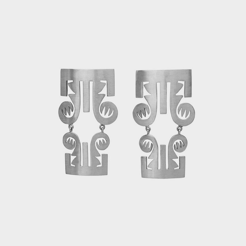 Aretes trompas precolombino en plata, foto con vista frontal. Joyería artesanal inspirada en arte precolombino. Diseños exclusivos, hecho en Colombia por Mariana Shuk.