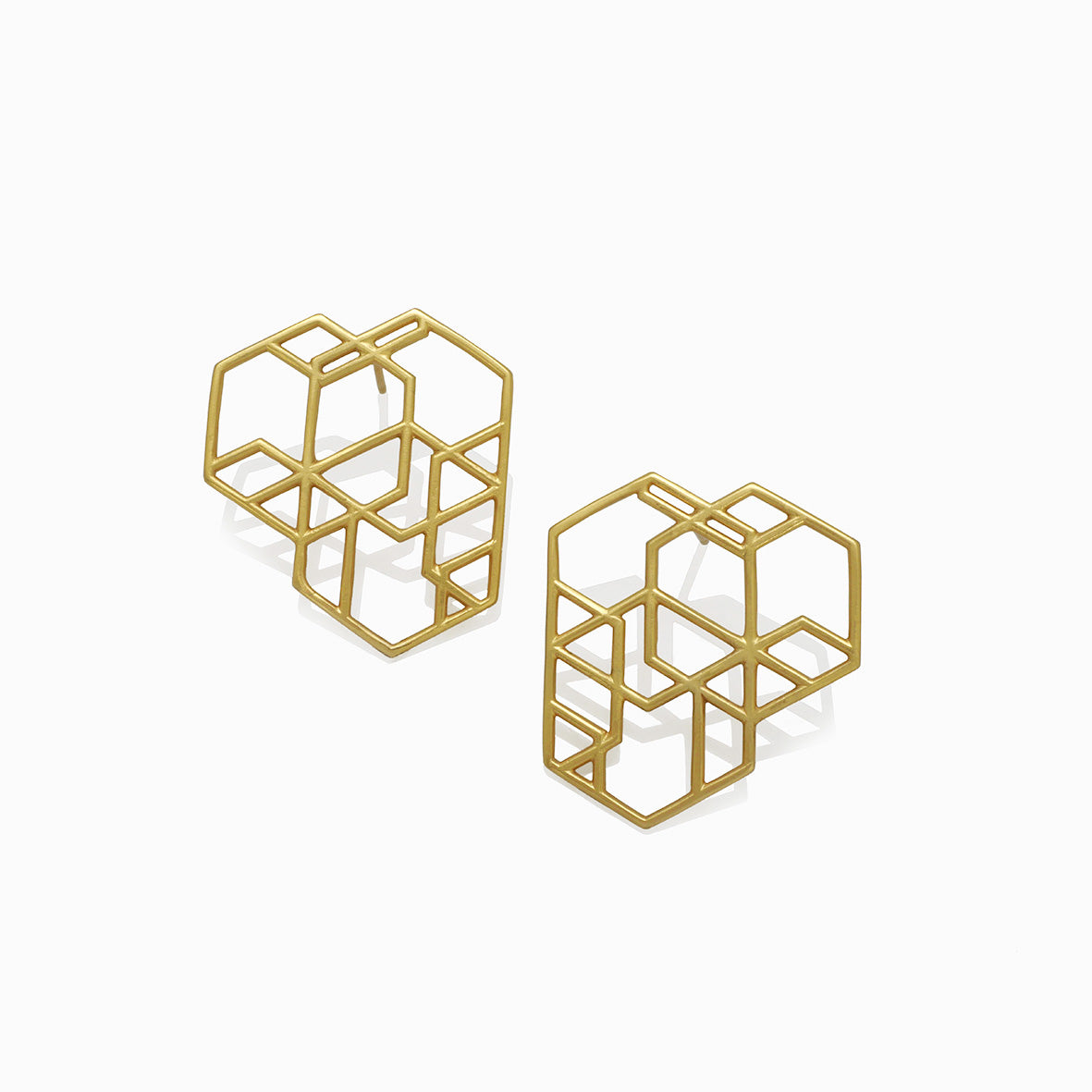 Aretes hexágonos entrelazados grande en plata con enchape de oro, foto frontal. Joyería de autor, hecho en Colombia por Mariana Shuk.