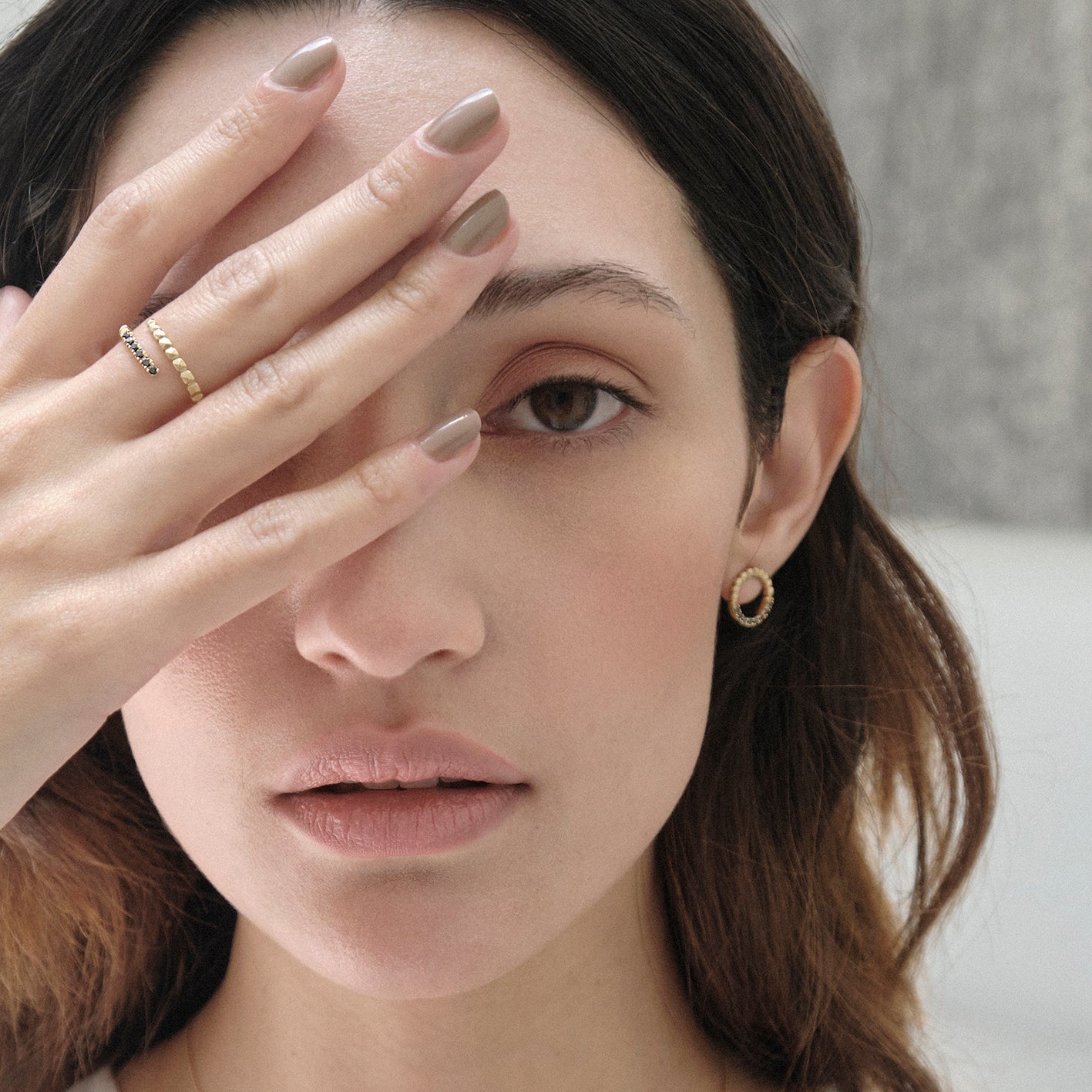Aretes círculo taches en oro 18k amarillo con diamantes negros, vista frontal en modelo, alta joyería hecha a mano en Colombia.