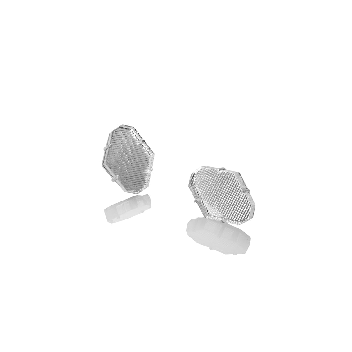 Aretes hexágono pequeños en acrílico espejado plateado, foto con vista frontal. Joyería artesanal con reflejos fríos y equilibrio geométrico. Diseños exclusivos, hecho en Colombia por Mariana Shuk.
