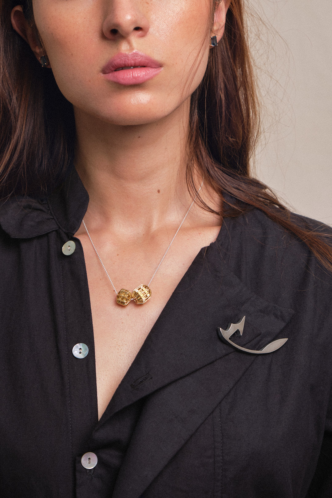 Broche hoja FLW en plata 925, y cadena dos globos, vista con modelo. Joyería de autor, hecho en Colombia por Mariana Shuk.