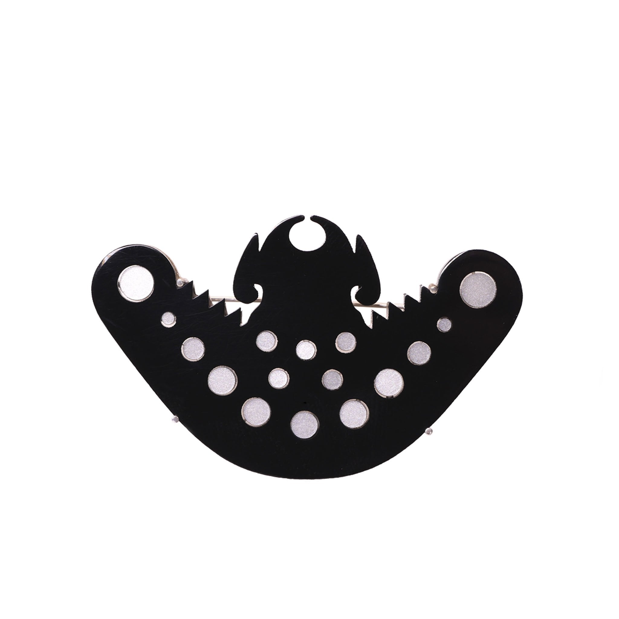 Broche murciélago precolombino N/B en acrílico blanco perlescente y negro, foto con vista frontal. Joyería artesanal inspirada en arte precolombino. Diseños exclusivos, hecho en Colombia por Mariana Shuk.