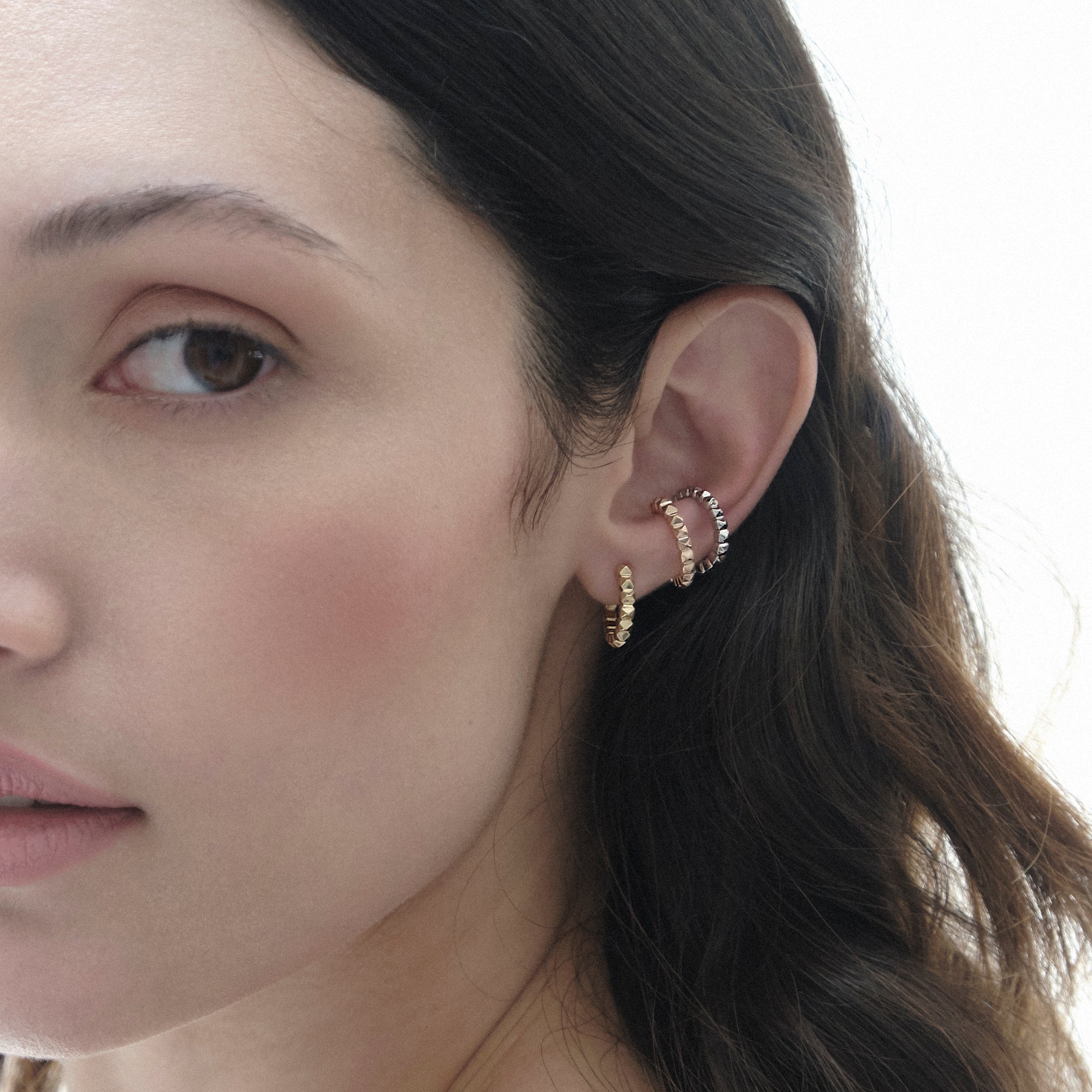 Orejeras con taches en oro amarillo, blanco o rosado de 18k, vista modelo, alta joyería hecha a mano en Colombia.