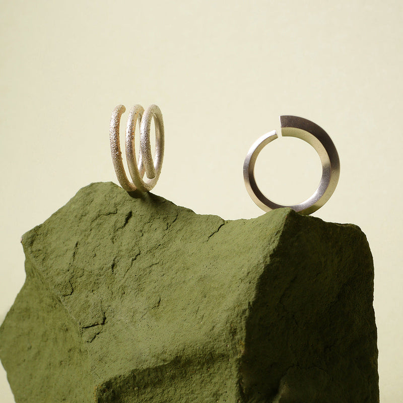 Anillo serpiente Taches de oro y plata, y anillo reticulado Taches, foto ambientada. Joyería de autor, hecho en Colombia por Mariana Shuk.