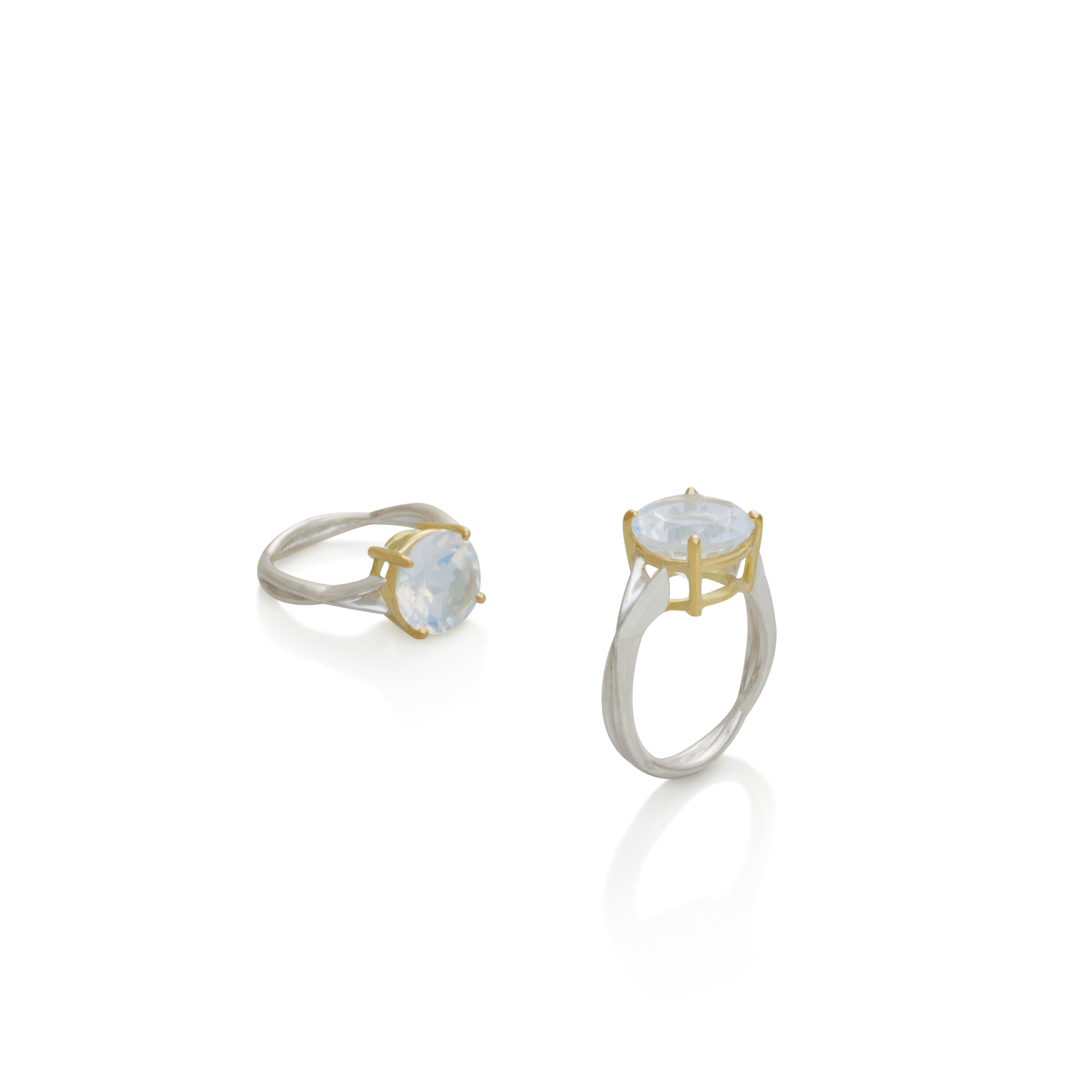 Anillo entrelazado en plata 0.925 con piedra luna azul redonda de 10 mm, joyería de autor hecha a mano en Colombia por Mariana Shuk.