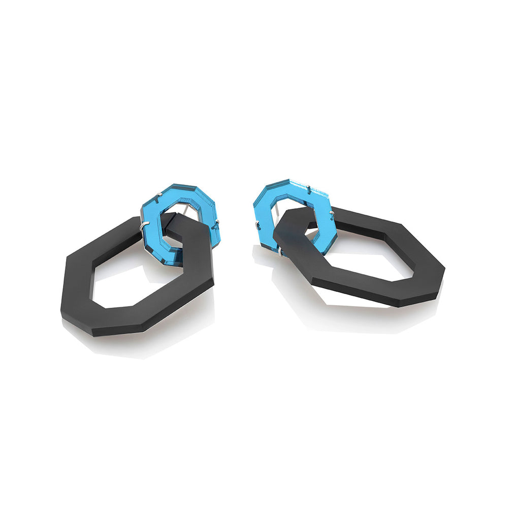 Aretes dos hexágonos en acrílico esmerilado negro y acrílico espejado azul claro, foto con vista frontal. Joyería artesanal que combina luz y transparencia. Diseños exclusivos, hecho en Colombia por Mariana Shuk.