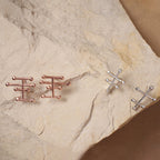 Aretes Taches mini en plata y con enchape de oro rosado, foto ambientada con piedra. Joyería de autor, hecho en Colombia por Mariana Shuk.