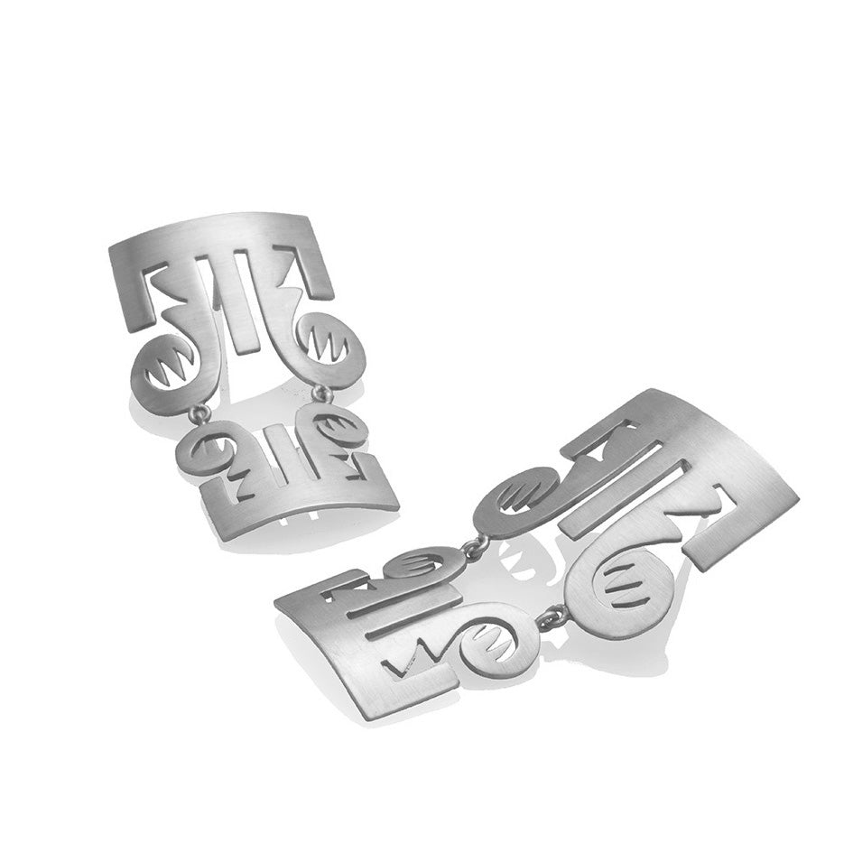 Aretes trompas precolombino en plata, foto con vista superior. Joyería artesanal colombiana inspirada en símbolos femeninos ancestrales. Diseños exclusivos, hecho en Colombia por Mariana Shuk.