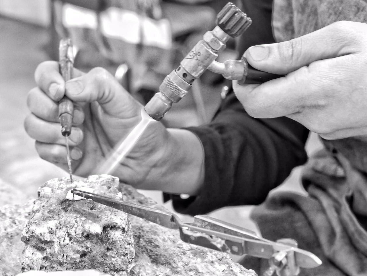 Primer plano de las manos de la joyera colombiana Mariana Shuk soldando una joya artesanal en su taller de Bogotá.