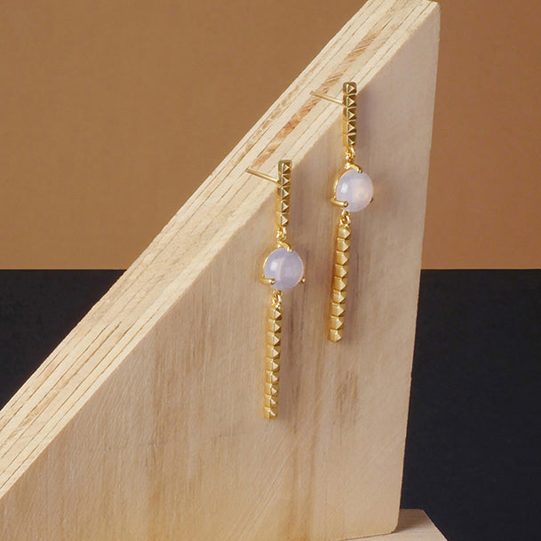 Pendientes móviles con taches y piedra luna lavanda, foto ambientada. Joyería de autor, hecho en Colombia por Mariana Shuk.