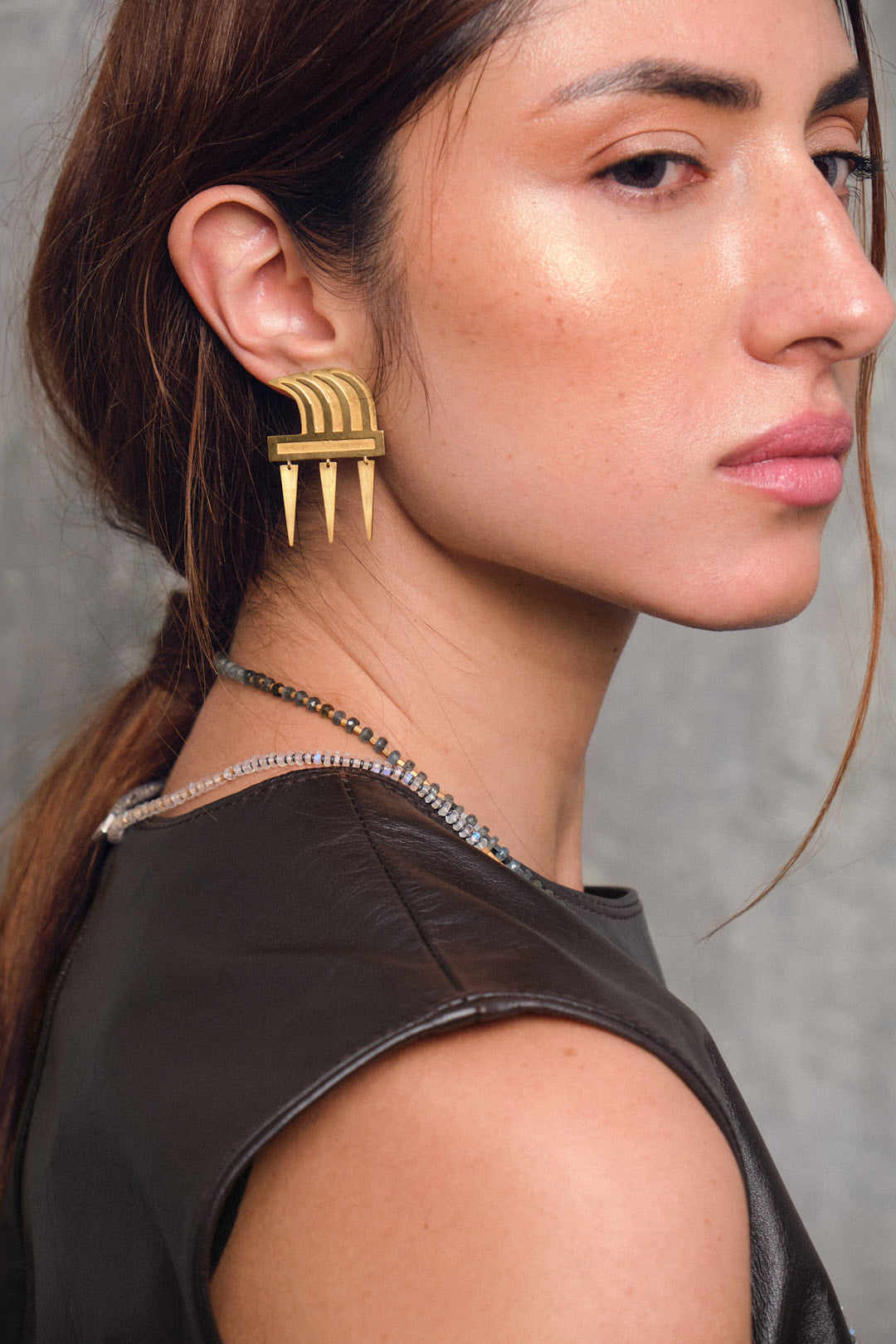 Aretes cangrejo precolombino en plata con enchape en oro, con collares de miyuki, foto con vista lateral de modelo. Joyería de autor con símbolos ancestrales reinterpretados. Diseños exclusivos, hecho en Colombia por Mariana Shuk.