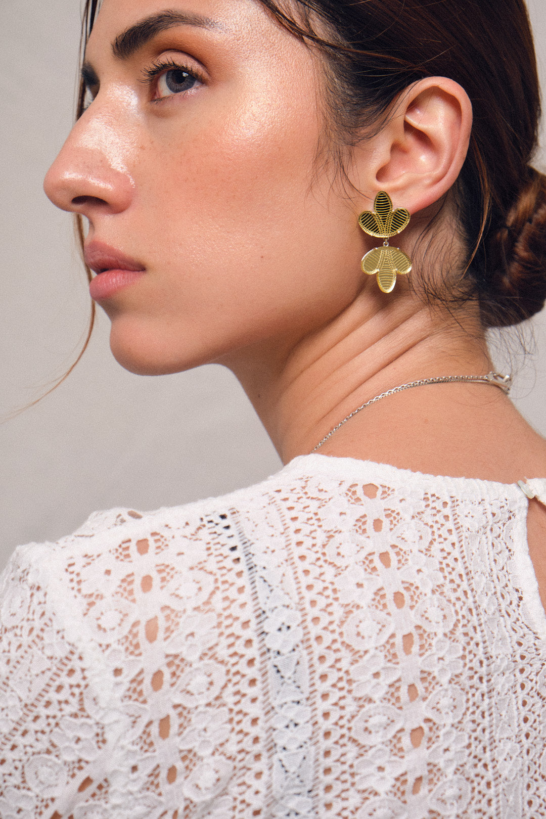 Aretes hojas espejo en plata y acrílico, color dorado, vista con modelo. Joyería de autor, hecho en Colombia por Mariana Shuk.