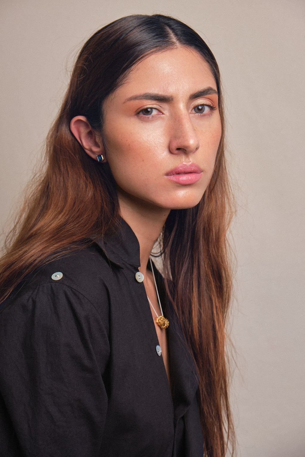 Aretes topos de oro rosado 18k con topacio London talla octagono 7x5mm, vista con modelo y collar. Joyería de autor, hecho en Colombia por Mariana Shuk.