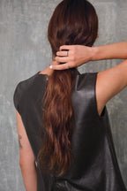 Argolla en platino 0.950 con 34 diamantes negros de 1.6 mm, vista frontal en mano de modelo de espaldas, joyería de autor hecha a mano en Colombia.