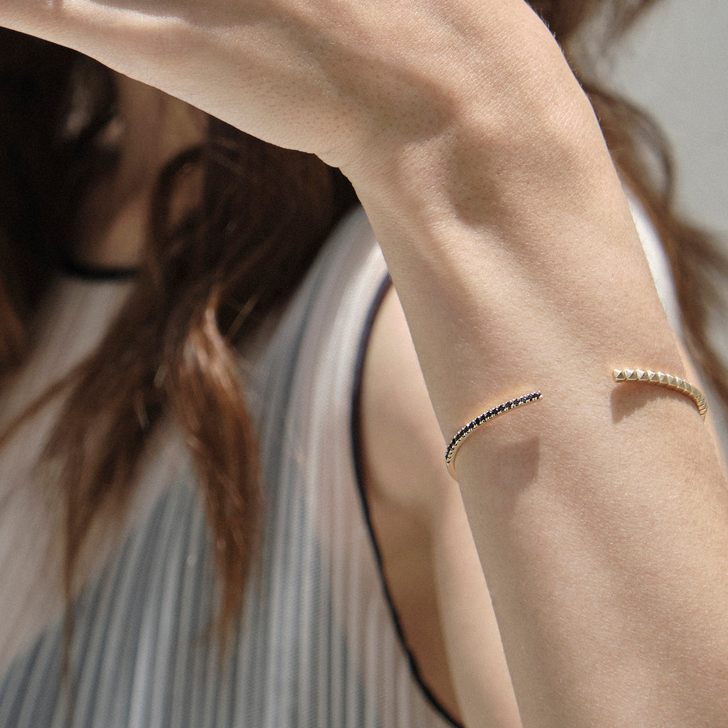 Brazalete en oro amarillo 18k con diamantes negros con modelo, joyería de autor, hecho en Colombia por Mariana Shuk.