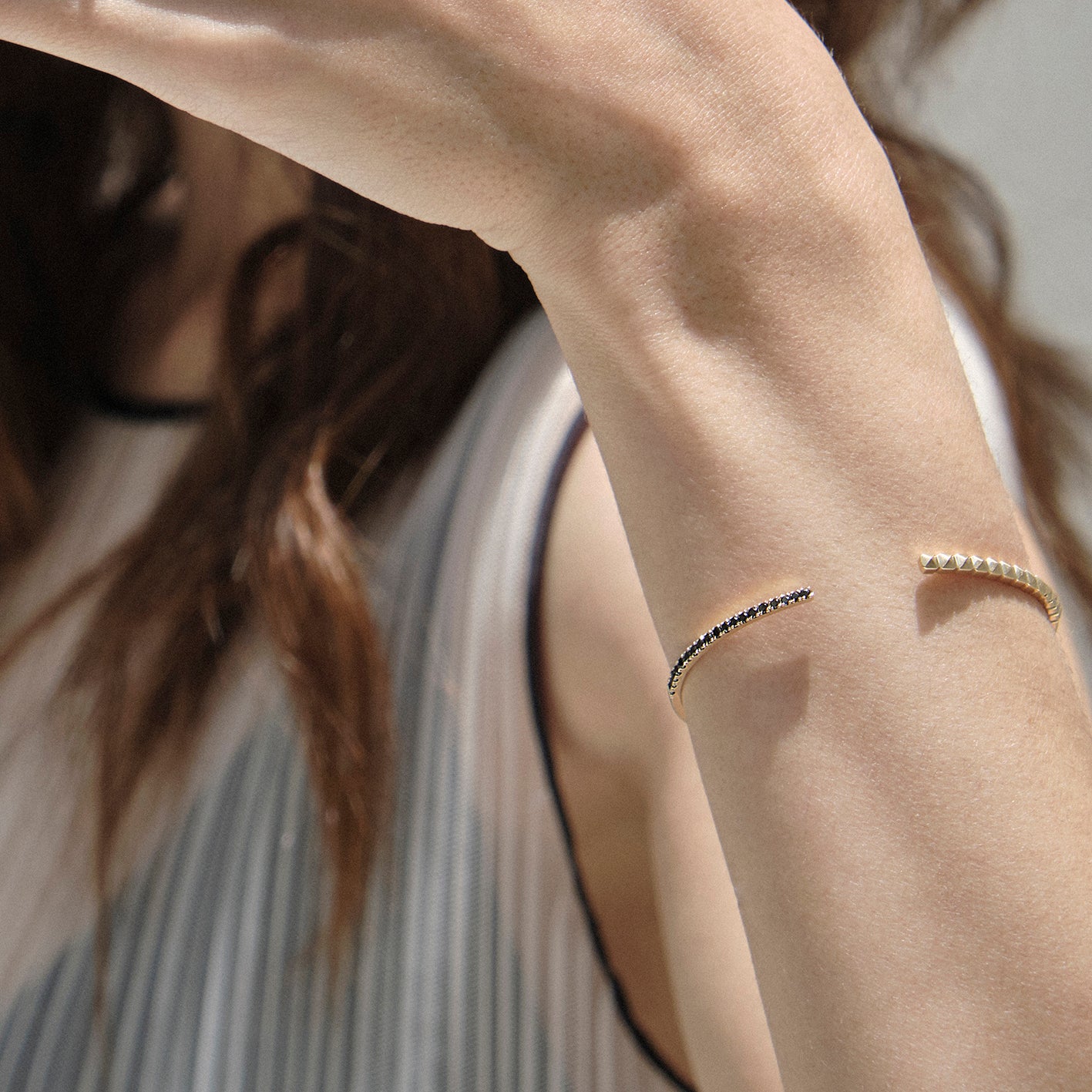 Brazalete en oro amarillo 18k con diamantes negros con modelo, joyería de autor, hecho en Colombia por Mariana Shuk.