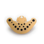 Broche murciélago precolombino D/N en acrílico dorado perlescente y negro, foto con vista frontal. Joyería artesanal inspirada en arte precolombino. Diseños exclusivos, hecho en Colombia por Mariana Shuk.