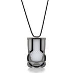 Dije Vessels humo negro blanco con collar, foto con vista frontal. Joyería artesanal en acrílico y plata con soporte en neopreno. Diseños exclusivos, hecho en Colombia por Mariana Shuk.