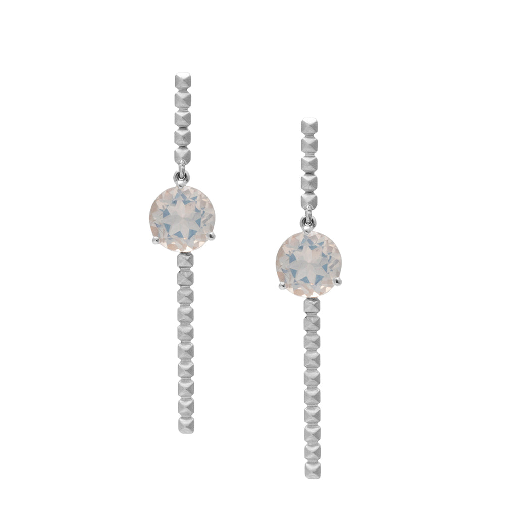 Pendientes largos en oro blanco 18k con piedra luna azul vista frontal. Joyería de autor, hecho en Colombia por Mariana Shuk.