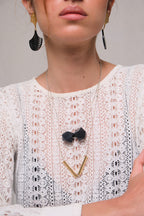 Pendientes Palma Deco, collar dos poliedros acrílico, collar con dije tubos, foto con modelo. Joyería hecha a mano que combina elegancia minimalista y estructura. Diseños exclusivos, hecho en Colombia por Mariana Shuk.